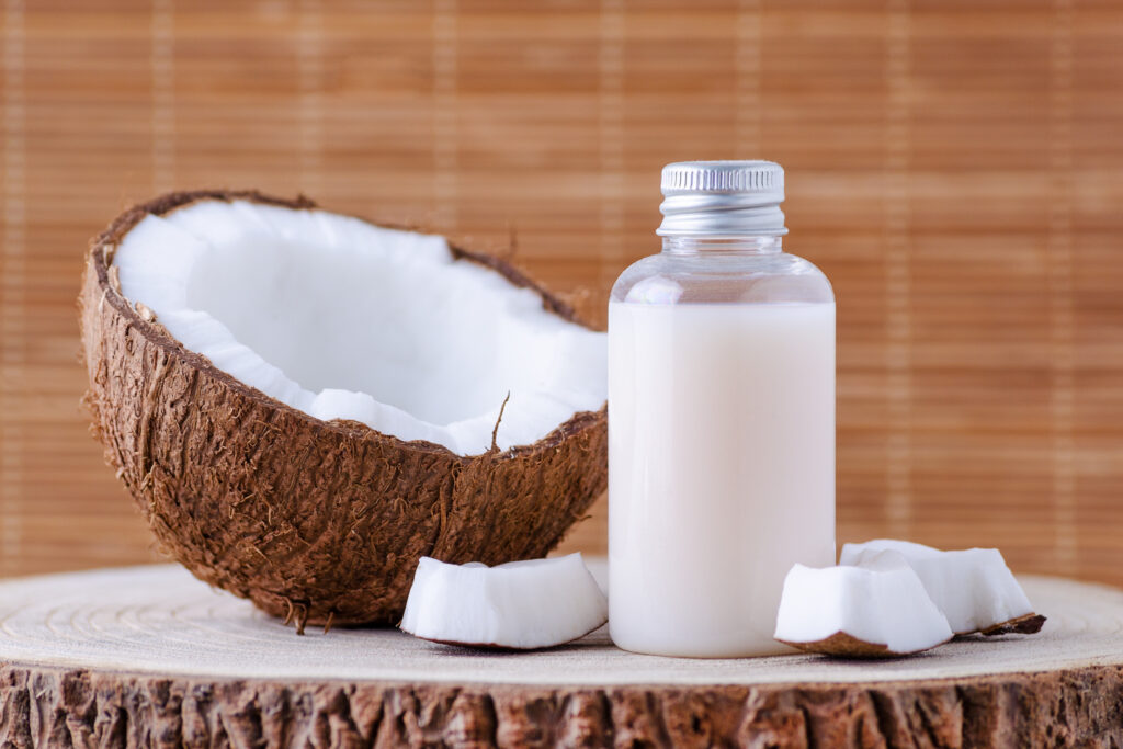 cosmetic bottle and fresh organic coconut for skincare by Phibel Naturals