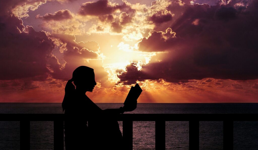 woman reading a book at sunset